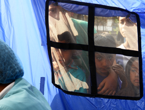 Young spectators at a window of our operating tent